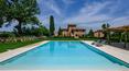Toscana Immobiliare - Qui, a bordo piscina, un ampio patio rappresenta il perfetto angolo ombreggiato per i pomeriggi di svago. 