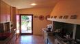 Toscana Immobiliare - kitchen with fireplace of the elegant villa in sardinia surrounded by a luxuriant garden with swimming pool