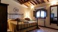 Toscana Immobiliare - wonderful bedroom with panoramic window and wooden ceiling beams