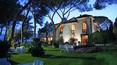 Toscana Immobiliare - The park, filled with ancient trees, hosts a beautiful outdoor swimming pool surrounded by large palm trees and tall, shady trees