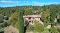 Toscana Immobiliare - La ferme présente des pierres de grès toscanes apparentes, des poutres en bois ancien et des sols en terre cuite rouge.