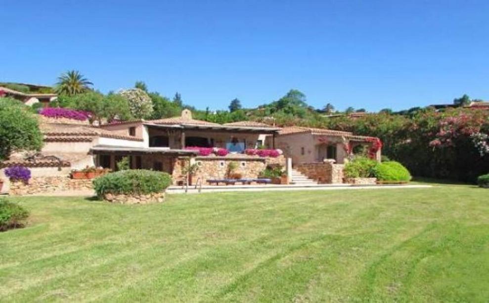 Toscana Immobiliare - Front view of the elegant villa in sardinia surrounded by a luxuriant garden with swimming pool
